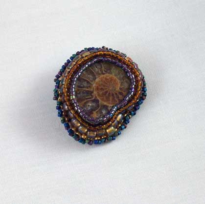 Amonite fossil brooch,beaded,brown with blue greys